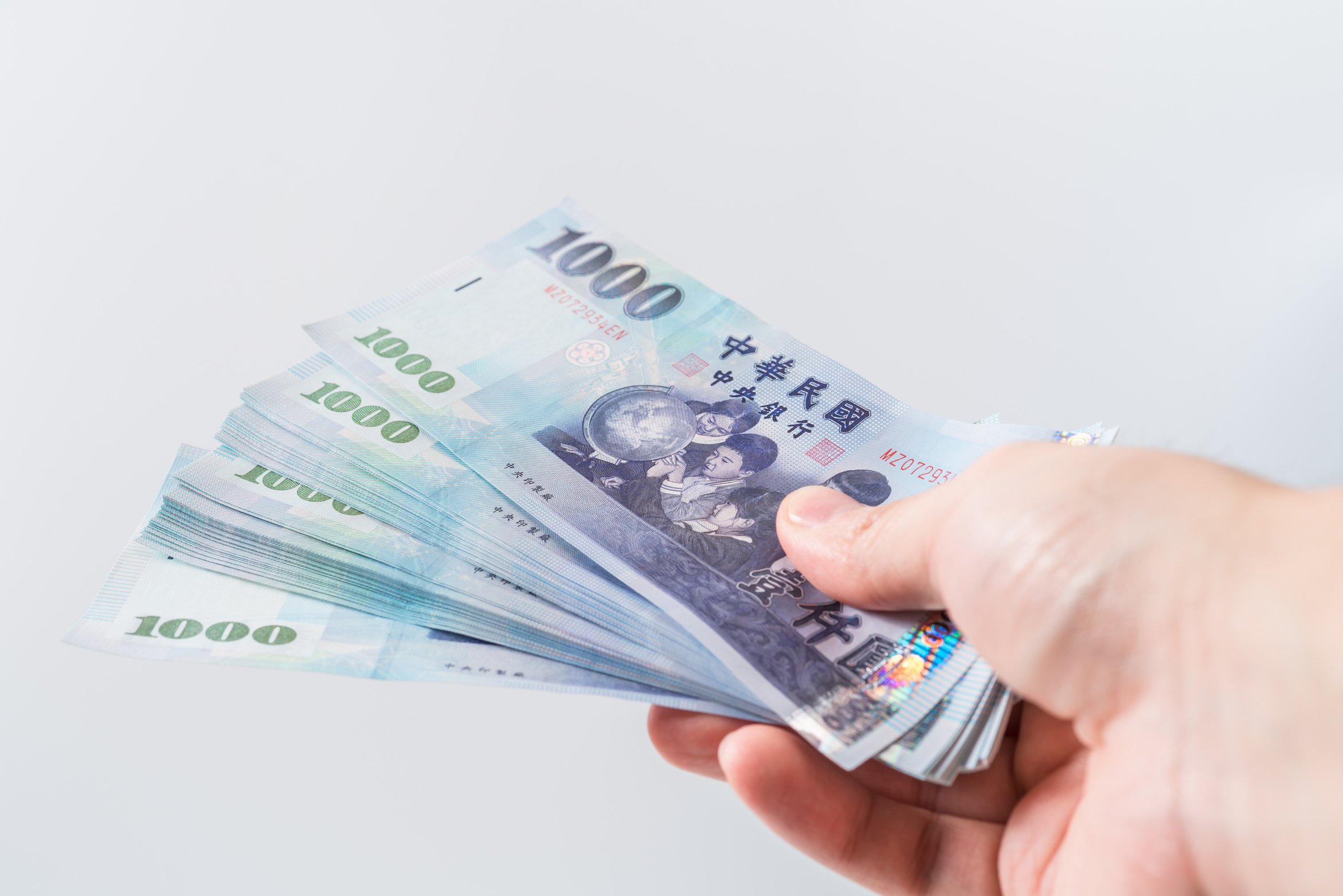 A Hand Holding a 1000 New Taiwan Dollar Bill.